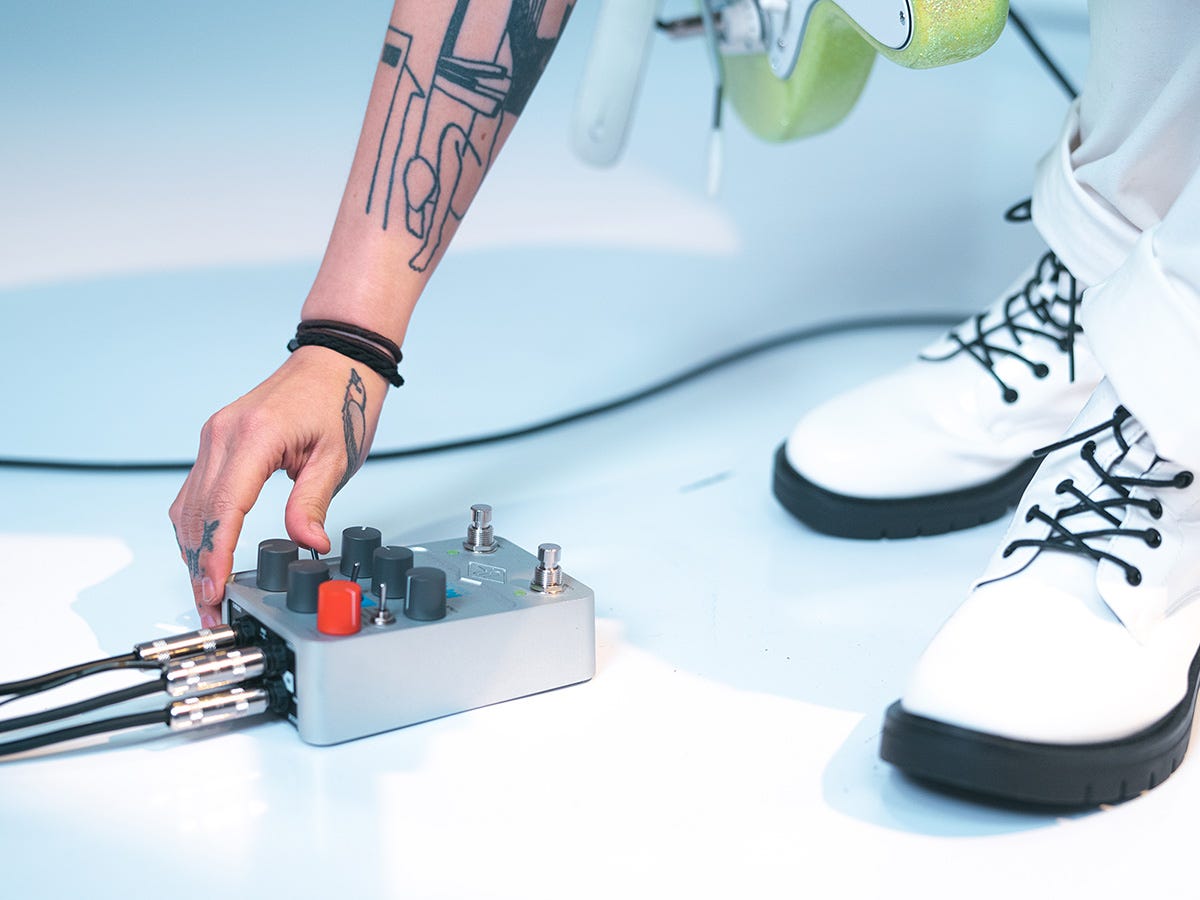 En tilkoblet UAFX Max Preamp & Dual Compressor foran et par hvite sko.