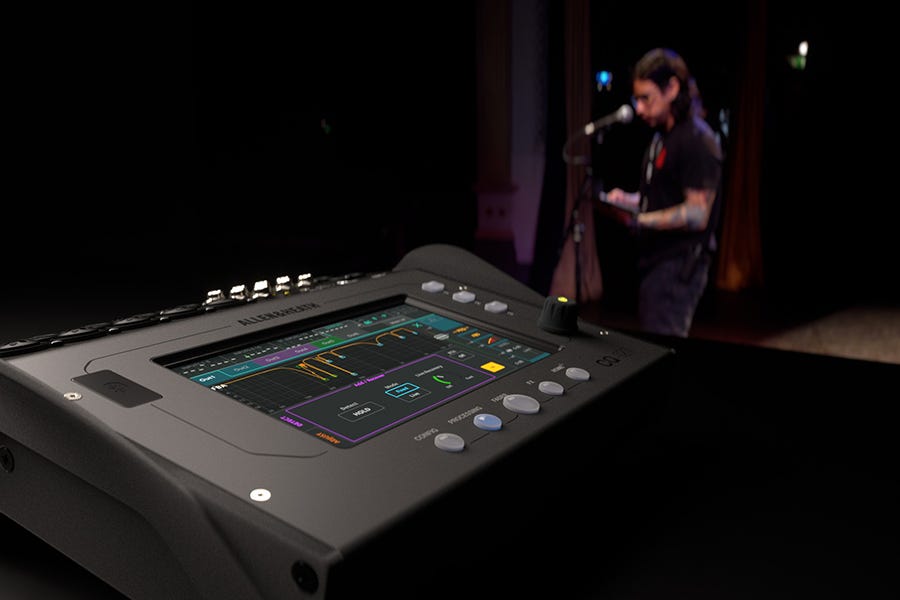 Allen & Heath CQ12T i forgrunnen, en musiker spiller i bakgrunnen.